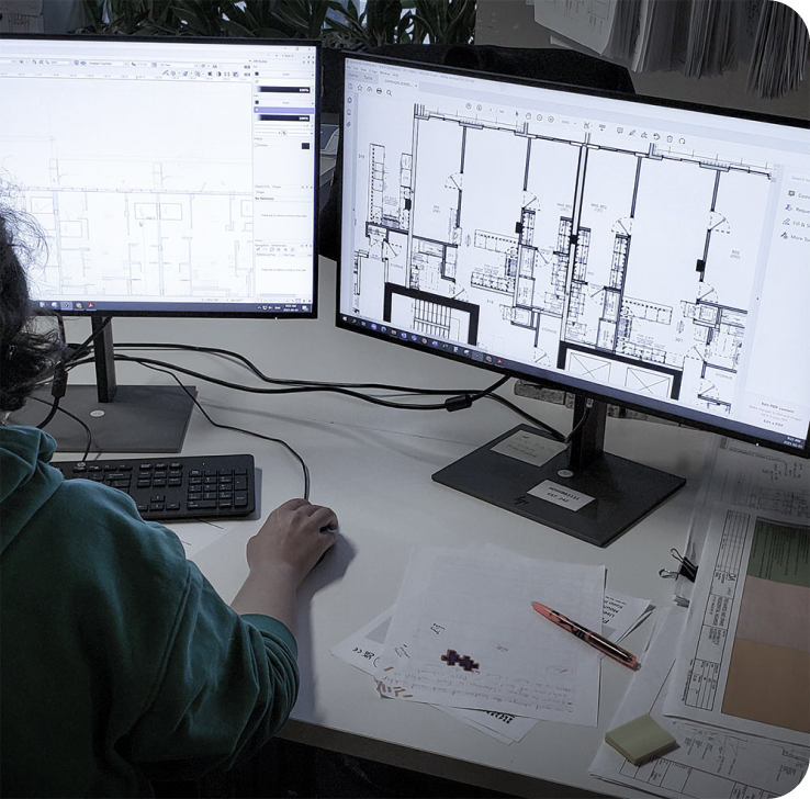 woman working on drafting with dual monitors